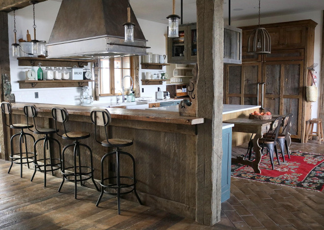 Rustic Kitchen. Rustic Kitchen cabinet. The idea was to use a variety of woods, and color combinations to achieve a look of multiple found pieces instead of looking like built ins, but with the functionality of a modern kitchen. We also chose to use chicken wire for some of the doors to achieve a rustic feel. The hanging cabinetry above the kitchen island was to add more storage space. It is made out of reclaimed Wyoming fence, and is suspended from the ceiling by industrial pipes. #RusticKitchen #cabinet Home Bunch's Beautiful Homes of Instagram @birdie_farm