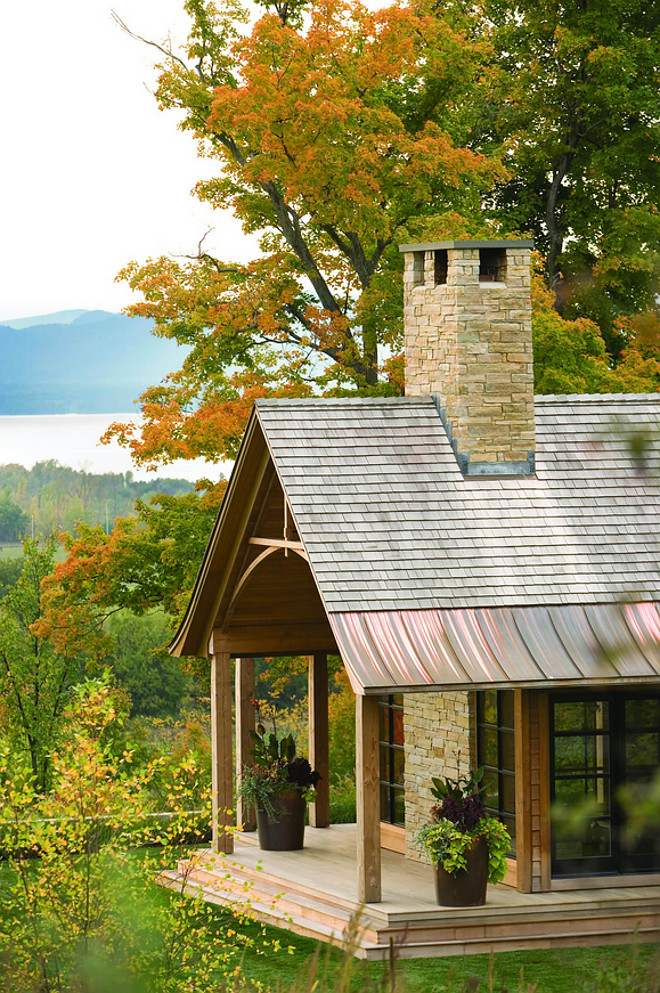 Cabin with shake roof with copper and stone chimney. Stone is Adirondack Buff. The roofing is natural wood red cedar shingles. The roof edge is copper standing seam. #Cabin #shakeroof #stonechimney Roundtree Construction. TruexCullins Architecture + Interior Design