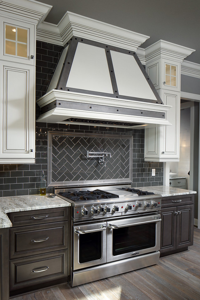 Charcoal Gray Subway Tile. This Interglass Shimmer ceramic tile was the perfect choice for this beautiful kitchen backsplash. White grout gives a modern edge to this charcoal subway tile. Tile: The backsplash is from InterCeramic and it is their Interglass Shimmer line in Pewter. Countertop: The countertop in this kitchen is a Quartzite called Fantasy Brown (or Canyon Dawn). Charcoal Gray Subway Backsplash Tile. Two toned kitchen with Charcoal Gray Subway Tile and powder coated hood with zic stripes. #charcoaltile #charcoalsubwaytile #subwaytile #subwaybacksplashtile Barrington Homes Inc.