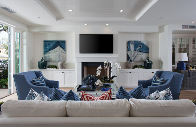 Crisp white living room with blue accessories and built-ins flanking fireplace. Brandon Architects, Inc.