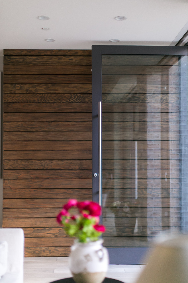 Entry with black steel and glass door and stained shiplap paneling. #Entry #blacksteelandglassdoor #stainedshiplappaneling #stained #shiplappaneling Patterson Custom Homes