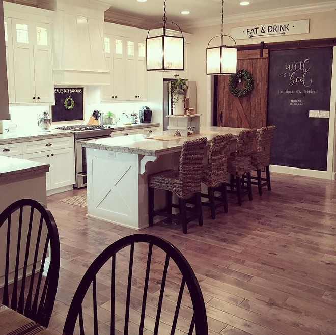Farmhouse Kitchen. Farmhouse kitchen with reclaimed wood barn door to pantry. "When we were building our home, the barn door was originally supposed to be a "new" looking (painted) door. At the last minute, I decided our "new" kitchen needed some rustic love! :) The barn door was custom made using some locally salvaged barn wood. As soon as I saw the pile of wood that would eventually become our barn door, I fell in LOVE! For the chalkboard, our builder backed it with a thin plywood type material, so we'd have a smooth surface for the chalkboard. I painted 3 coats of chalkboard paint (purchased at Lowe's), and used a foam roller for smooth application. The barn door/chalkboard is our favorite feature in the house!" Farmhouse Kitchen. Farmhouse kitchen with reclaimed wood barn door to pantry and chalk painted wall. #Farmhouse Kitchen. #Farmhousekitchen #Farmhouse #kitchen #reclaimedwood #barndoor #reclaimedbarndoor #pantry #barndoorpantry #pantrybarndoor @yellowprairieinteriors Via Instagram