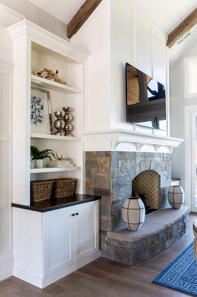 Fireplace. Stone base fireplace with white paneling above and white mantel with small corbels. Fireplace also features built-ins on both sides. #Fireplace #Stonebasefireplace #Stonefireplace #fireplacewhitepaneling whitepaneling above #whitemantel #mantelcorbel #corbels #fireplacebuiltin Timberidge Custom Homes