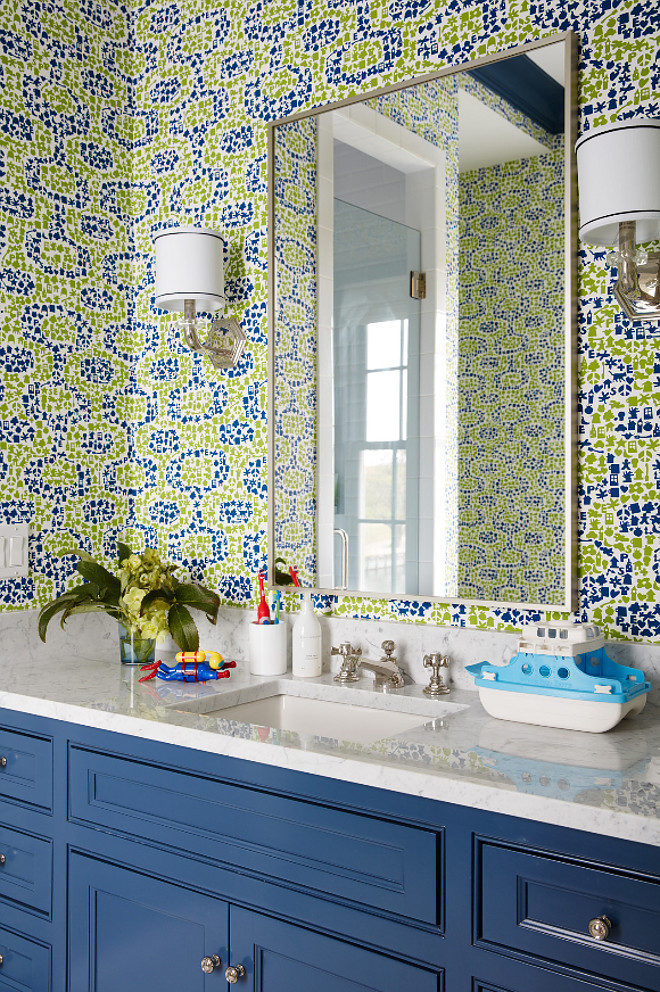 Kids bathroom wallpaper. Kids with bold bathroom wallpaper, blue vanity and white carrara marble countertop. Vanity paint color is "Benjamin Moore 1680 Hudson Bay". #BenjaminMoore1680HudsonBay #BenjaminMooreHudsonBay #Kidsbathroom #Kidsbathroomwallpaper #Boldwallpaper #bluevanity #whitecarraramarble Andrew Howard Interior Design