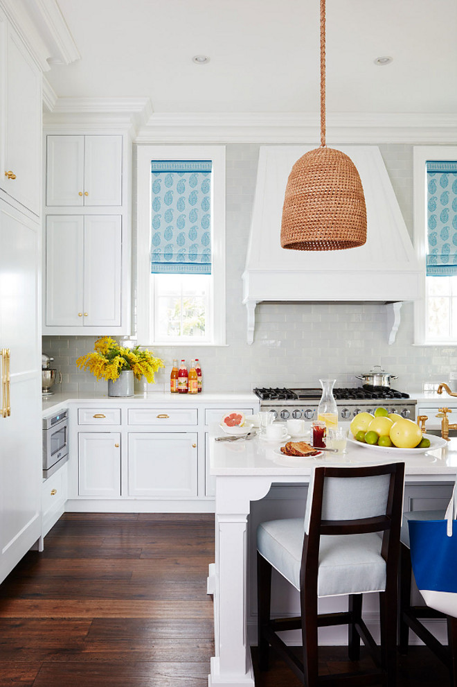 Kitchen. White kitchen with blue Roman Shades. Kitchens. Cabinets are painted in "Benjamin Moore White Diamond". White kitchen Roman Shades. The window shades are done in a Peter Dunham Textiles linen. The rattan pendant is the Green Oaks Pendant by Palecek. #Kitchen #RomanShades #Blueromanshades #Kitchens #BenjaminMooreWhiteDiamond Andrew Howard Interior Design