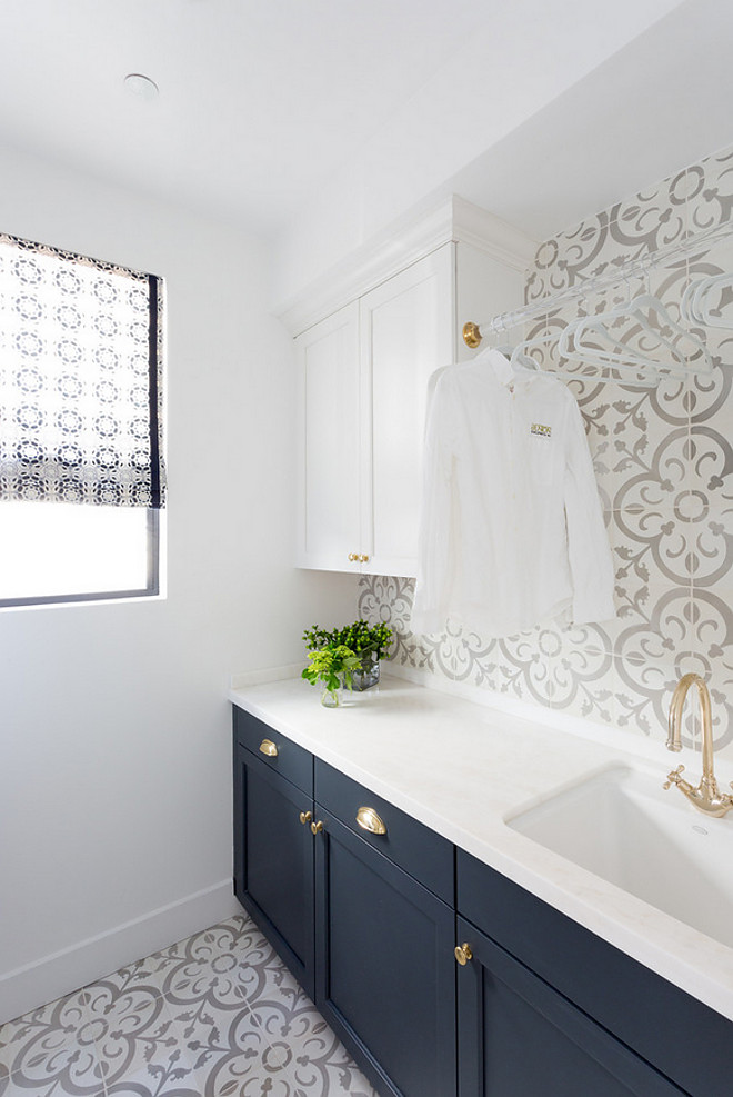 This two-toned laundry room features cabinets painted in white and navy, cement tile flooring, cement tile backsplash and lucite drying rod. #Twotonedcabinet #Twotonedlaundryroom #laundryroomcabinets #whiteandnavytwotonedcabinets #paintcolors #laundryroom #cementtileflooring #cementtile #cementtilebacksplash #lucitedryingrod #dryingrod Denton Developments