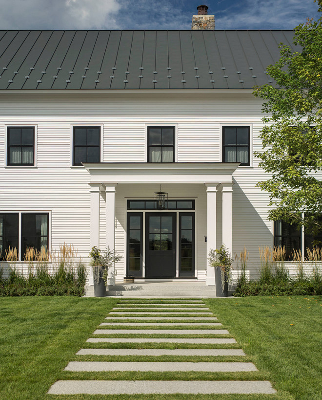 White Farmhouse with black pane windows, black metal roof and black front door. Modern White Farmhouse with black pane windows, black metal roof and black front door #WhiteFarmhouse #Farmhouse #blackpanewindows #blackmetalroof #metalroof #blackfrontdoor #ModernWhiteFarmhouse #blackdoor Roundtree Construction. TruexCullins Architecture + Interior Design