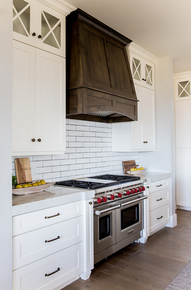 White kitchen with dark walnut hood. White kitchen with dark stained walnut hood and X Mullion Upper Cabinets. White kitchen with dark stained hood. White kitchen with dark walnut stained hood and X Mullion Upper Cabinets #Whitekitchen #darkwalnuthood #darkstainedwalnuthood #XMullionUpperCabinets #XUpperCabinetdoor Timberidge Custom Homes