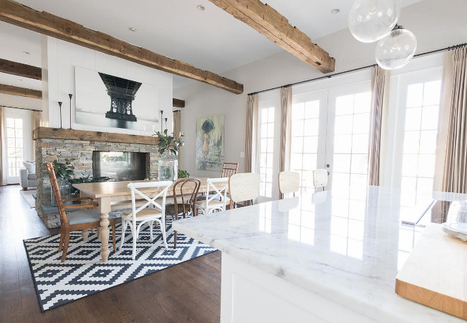 Farmhouse kitchen and dining area with double-sided stacked stone fireplace and ceiling beams #Farmhousekitchen #farmhousediningarea #doublesidedfireplace #stackedstonefireplace #ceilingbeams Beautiful Homes of Instagram @greensprucedesigns