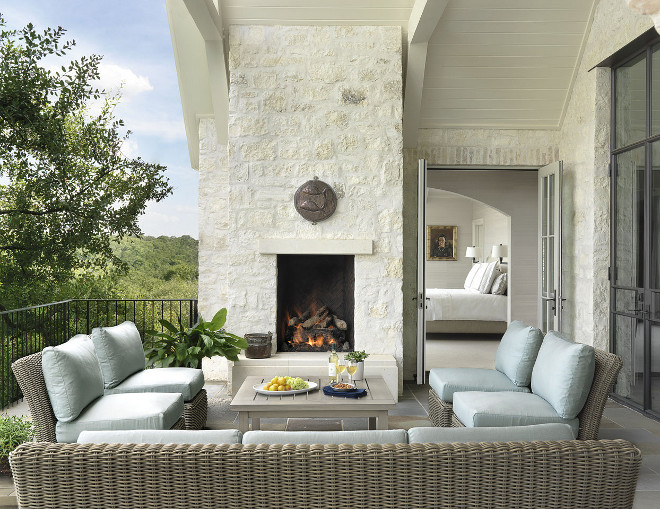 Patio with white stone outdoor fireplace, black steel doors and bluestone floor tile. #Patio #whitestone #outdoorfireplace #blacksteeldoors #bluestonetile #bluestonefloortile #Ryan Street & Associates Greer Interior Design.