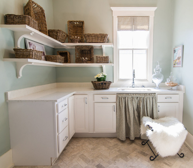 Coastal Farmhouse Laundry Room. Coastal Farmhouse Laundry Room with open shelves, wicker baskets, skirted sink, herringnbone floor tile and walls painted in Benjamin Moore Palladian Blue #CoastalFarmhouse #LaundryRoom #CoastalFarmhouseInteriors #CoastalFarmhouseLaundryRoom #openshelves #wickerbaskets #skirtedsink #herringnbone #floortile #BenjaminMoorePalladianBlue Our Town Plans