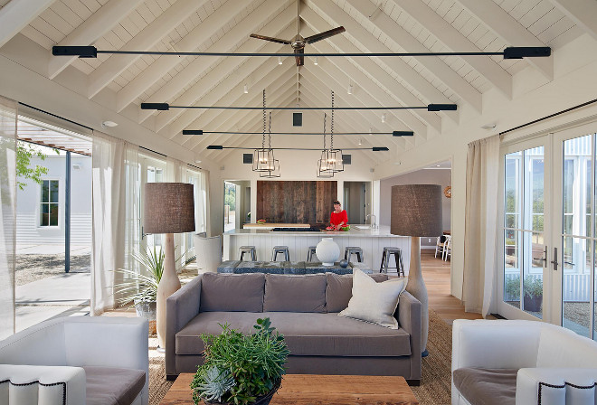 Open Living room and Kitchen with vaulted ceiling and exposed rafters. The rafter brackets were fabricated by a local steel worker per spec from the structural engineer. Rafters are 2x12's at 24" on center - construction grade painted white. The roof pitch is 10:12. Open Living room and Kitchen with vaulted ceiling and exposed rafters. Open Living room and Kitchen with vaulted ceiling and exposed rafters #OpenLivingroom #OpenKitchen #vaultedceiling #exposedrafters Nick Noyes Architecture