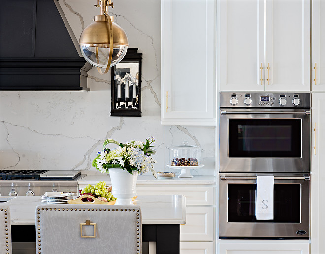 Quartz Countertop and quartz backsplash, For the countertops, the designer selected a stunning quartz. “I knew I wanted to mimic marble, but marble isn’t the best choice for busy people and families in their kitchens because it’s porous and stains easily.” She loved the quartz so much that she decided to use it above the range too. #Quartz #Countertop #backsplash Sarah St. Amand Interior Design, Inc 