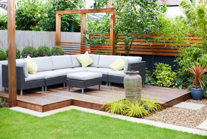 The rear deck - surrounded by plenty of evergreen planting to provide all year round interest and drama. This is a lovely place to sit in the late afternoon and early evening to enjoy the afternoon sun. The urn belonged to my client's aunt, and sits happily amongst the Carex elata 'Aurea #Reardeck #Deck Green Tree Garden Design Ltd