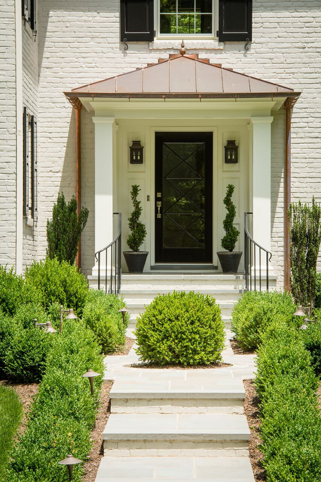 Traditional Front Entry. Traditional Front Entry Ideas. A stunning black front door and black shutters complement the painted brick and the copper roof and gutters. Traditional Front Entry with Painted brick exterior, copper roof, copper gutters and black front door #TraditionalFrontEntry #FrontEntry #TraditionalEntry #TraditionalEntryIdeas #Paintedbrick #Paintedbrickexterior #copperroof #coppergutters #blackfrontdoor #blackdoor Anthony Wilder Design/Build, Inc