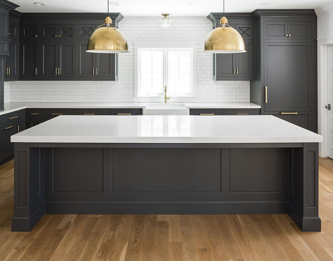 Black Kitchen Cabinets with White Quartz Countertop, White Oak Hardwood Floor, Brass accents and white subway tile with dark grout. Dark inset cabinets bring a modern feel to this classic kitchen. The overall size of the kitchen is 21’6” wide by 13’6” deep. The kitchen island is roughly 11’ wide by 4’6” deep. Kitchen lighting is Eugene Large Pendant - Hand-Rubbed Antique Brass from Circa Lighting. Black Kitchen Cabinets with White Quartz Countertop, White Oak Hardwood Floor, Brass accents and white subway tile with dark grout. #BlackKitchen #BlackKitchenCabinet #BlackKitchencabinets #Blackcabinets #WhiteQuartz #Countertop #whitequartzcountertop #WhiteOak #HardwoodFloor #Brassaccents #kitchenBrassaccents #whitesubwaytile #darkgrout Fox Group Construction