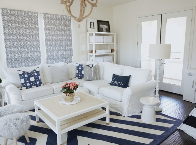 Sherwin Williams Dover White. Blue and white family room with white slipcovered sectional sofa, blue and white striped rug and white furniture. Sectional, pillows, coffee table and rug are from Serena & Lily. Paint Color is Sherwin Williams Dover White #SherwinWilliamsDoverWhite Beautiful Homes of Instagram @MyHouseOfFour