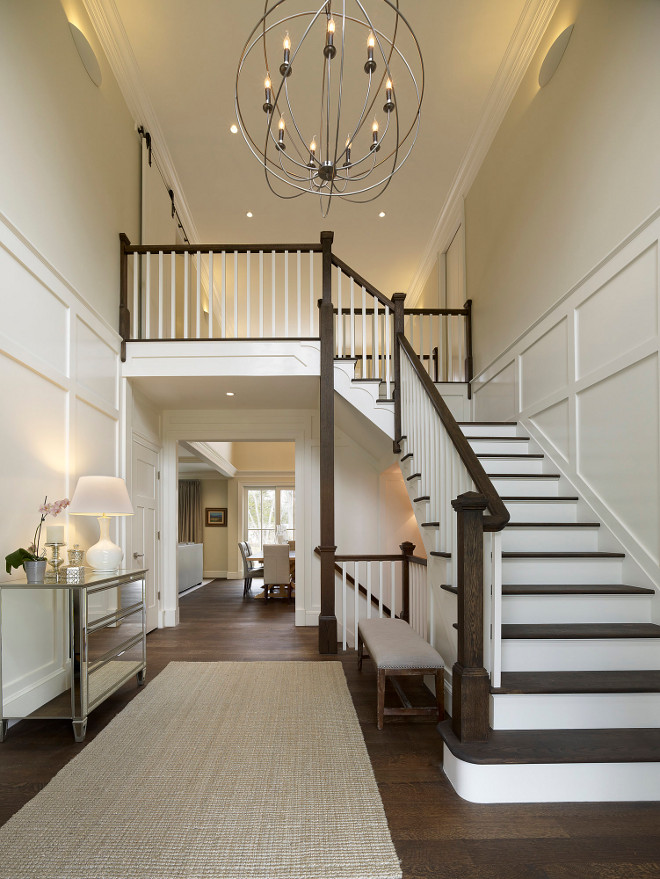 Foyer. A beautiful two story entry with large iron openwork globe and classic candleholder lights is welcoming and beautiful. Rift and quarter sawn oak flooring adds to the richness and warmth of this home. The Orb is from Restoration Hardware and the overall dimensions are 40.5 diameter and 43" H. #Foyer Knight Architects LLC