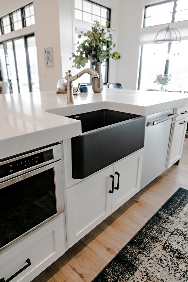 Black Farmhouse Sink. I topped the kitchen off with gorgeous, easy to maintain, marble look, quartz countertops. We used an extra thick 6cm quartz, with a mitered edge, to give the countertops a substantial look. My favorite feature may be the black silgranit, farmhouse sink from Blanco. The black sink, with brass faucet, set agains the white countertops and cabinetry is an absolute showstopper! #BlackFarmhouseSink #BlackSink #FarmhouseSink Sita Montgomery Interiors