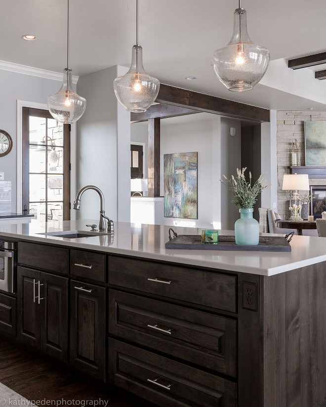Kitchen with dark stained island. Island is stained in a dark finish with a white quartz countertop. Glass pendants by Kichler Lighting. Kitchen island. Kitchen with dark stained island. #Kitchen #darkstainedisland Restyle Design, LLC.