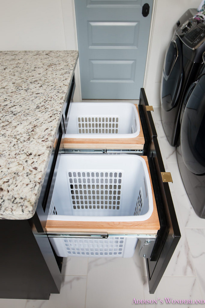 Laundry Room island with Pull Out Laundry Sorters. Laundry room boasts a black island topped with a white and gray granite countertop fixed above pull out drawers holding laundry sorters. #LaundryRoom #LaundryRoomisland #PullOut #LaundrySorters Home Bunch's Beautiful Homes of Instagram @addisonswonderland