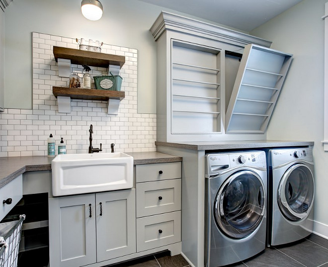 Laundry Room. Farmhouse Laundry Room. Fixer Upper Farmhouse Laundry Room with custom drying rack, subway tile backsplash, open shelves and farmhouse sink. Laundry Room #FarmhouseLaundryRoom #FixerUpperlaundryroom #Farmhouse #LaundryRoom #dryingrack #laundryroomsubwaytile #laundryroom #subwaytilebacksplash #laundryroomshelves #farmhousesink #fixerupper CVI Design