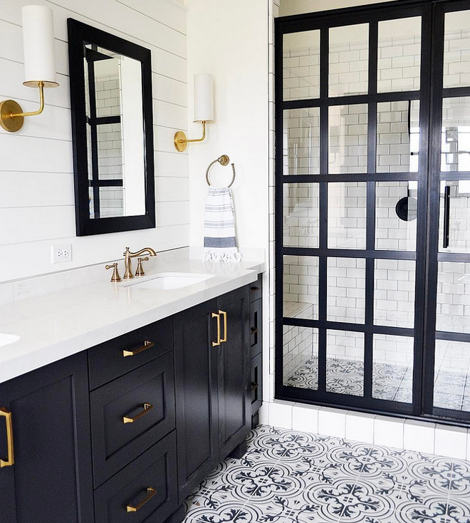 Modern Farmhouse Bathroom with black framed shower doors. Modern Farmhouse Bathroom with black framed shower door, black vanity, brass fixtures, shiplap paneled wall and cement floor tile. Shower screen door black metal and glass. #ModernFarmhouseBathroom #ModernFarmhousebathrooms #blackframedshowerdoors #blackshowerdoor #FarmhouseBathroom #blackframeshower #blackframeshowerdoor #shiplap #cementfloortile #cementtile