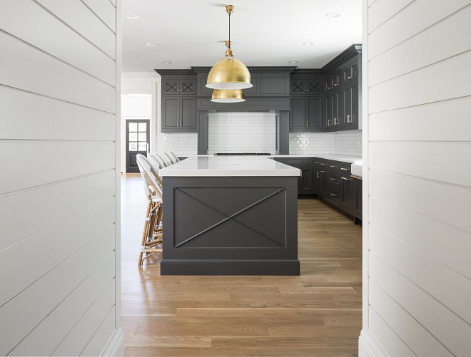 Shiplap Hall leading to kitchen with dark cabinets and brass accents. A hall with shiplap paneling leads to a mudroom. The white shiplap and walls are painted in Benjamin Moore Simply White. Shiplap Hall leading to kitchen with dark cabinets and brass accents. Shiplap Hall leading to kitchen with dark cabinets and brass accents. Shiplap Hall leading to kitchen with dark cabinets and brass accents #Shiplap #Hall #kitchen #darkcabinets #brass Fox Group Construction