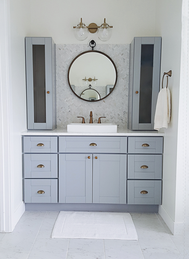 Grey Bathroom Cabinet. I didn't want to spend a lot. I really wanted to achieve a designer look on a budget. We were able to get the look we wanted on our budget this in several different ways. First, I went with RTA cabinets (ready to assemble) this saved us A LOT of money. RTA cabinets are usually about half the cost of custom cabinets and you can get several different finishes, styles and options to go with your design and budget. Grey Bathroom with grey cabinets, brass hardware, brass lighting and herringbone backsplash tile #GreyBathroom #GreyBathroomCabinet #Bathroom #grey cabinets #brasshardware #brasslighting #herringbonebacksplash #herringbonebacksplashtile #backsplashtile Home Bunch's Beautiful Homes of Instagram @household no.6