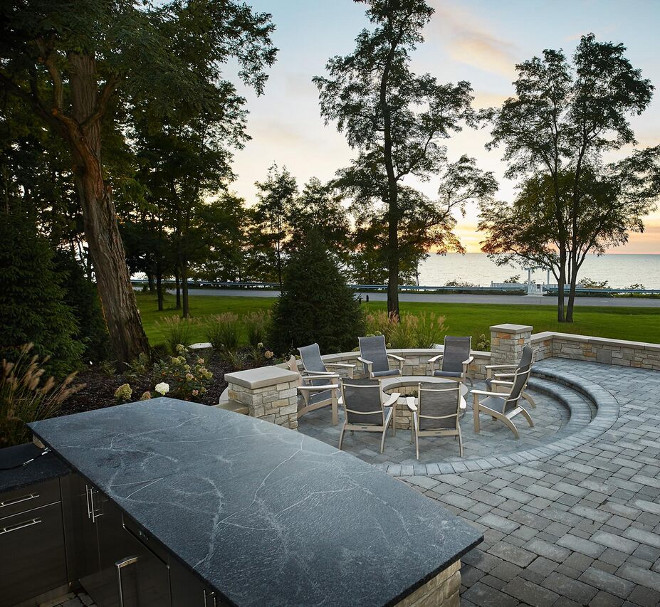 Outdoor Kitchen with honed Herdwick granite countertop and built-in firepit. The outdoor kitchen countertop is honed Herdwick granite. #OutdoorKitchen #honedcountertop #firepit #honedHerdwickgranite #Herdwickgranite #Herdwick #granite Benchmark Wood & Design Studios - Mike Schaap Builders