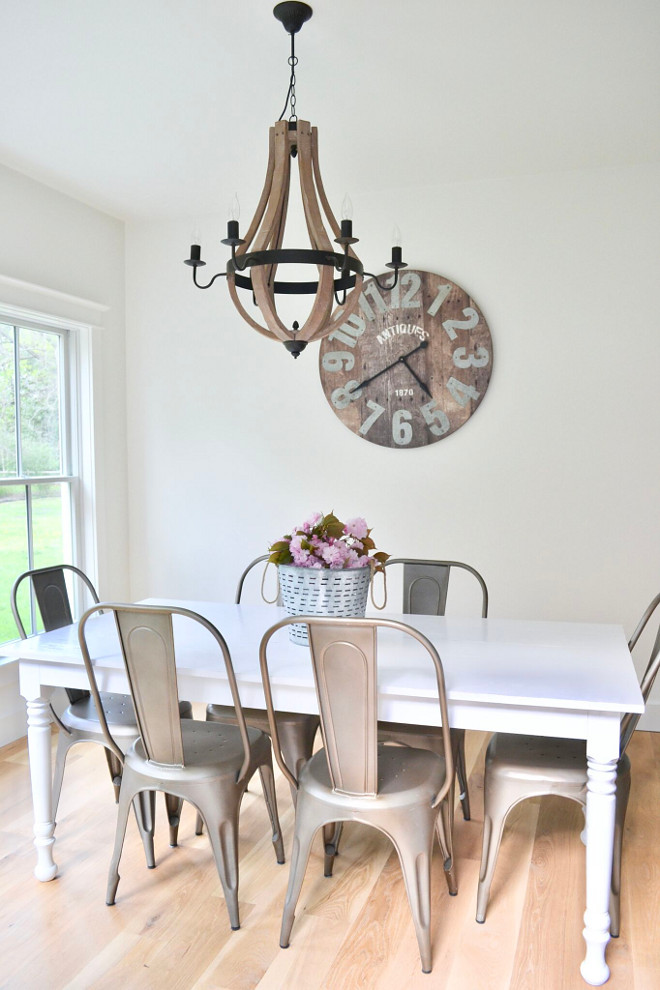 Farmhouse Breakfast Room. Right off the kitchen is our breakfast nook with a large farmhouse table built by my husband. This is where we eat dinner every night and the kids color or do homework. To tone down all the white in this area, I added the large wall clock and one of my favorite wood chandeliers. The wood tones really warm up the room and give it a more rustic feel. #FarmhouseBreakfastRoom #farmhouse #breakfastroom Home Bunch's Beautiful Homes of Instagram @sweetthreadsco