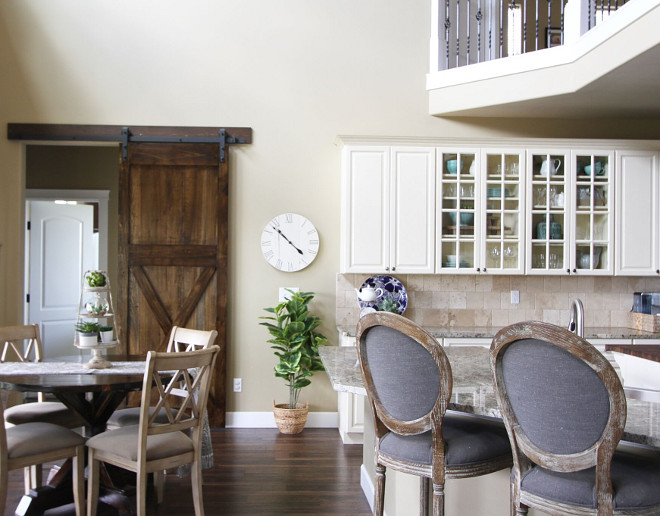 Farmhouse kitchen with creamy white cabinets, light tan walls and barn door. Home Bunch's Beautiful Homes of Instagram @AshleysDecorSpace_ 