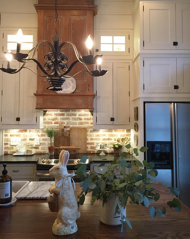 Farmhouse kitchen with stacked cabinets, brick backsplash and DIY reclaimed wood hood. We have used many reclaimed pieces...the oven hood is two vintage doors that were a yard sale find for $25 each. It did take three weekends to strip them three times to get the years of grime and paint off, but I think they are the perfect touch that just warms the kitchen so we're keeping it the way it is. Farmhouse kitchen with stacked cabinets, brick backsplash and DIY reclaimed wood hood. Farmhouse kitchen with stacked cabinets, brick backsplash and DIY reclaimed wood hood #Farmhousekitchen #farmhouse #kitchen #stackedcabinets #brickbacksplash #DIYreclaimedwoodhood #DIYhood Home Bunch's Beautiful Homes of Instagram @blessedmommatobabygirls