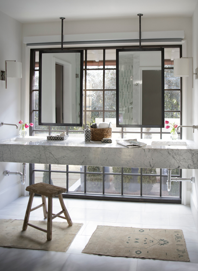 Floating vanity. Bathroom floating vanity. Marble floating vanity. This master bathroom features floating marble vanity, custom steel ceiling mounted mirrors, black steel windows and motorized privacy screen #bathroom #floatingvanity #marblefloatingvanity Christopher Architecture & Interiors