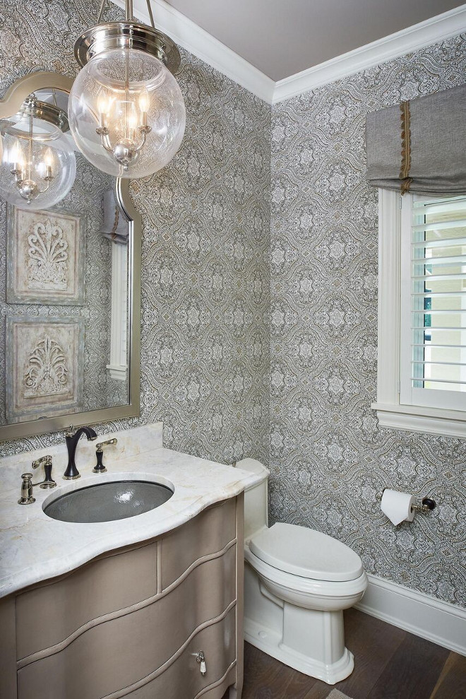 Grey Wallpaper. This grey powder room features a grey wallpaper, hardwood floors and a metallic grey vanity topped with white quartzite countertop. Grey powder room with grey wallpaper and metallic grey vanity. Lighting is Quoizel Soho 13.5-in Polished Nickel Industrial Multi-Light Clear Glass Bowl Pendant. Mike Schaap Builders