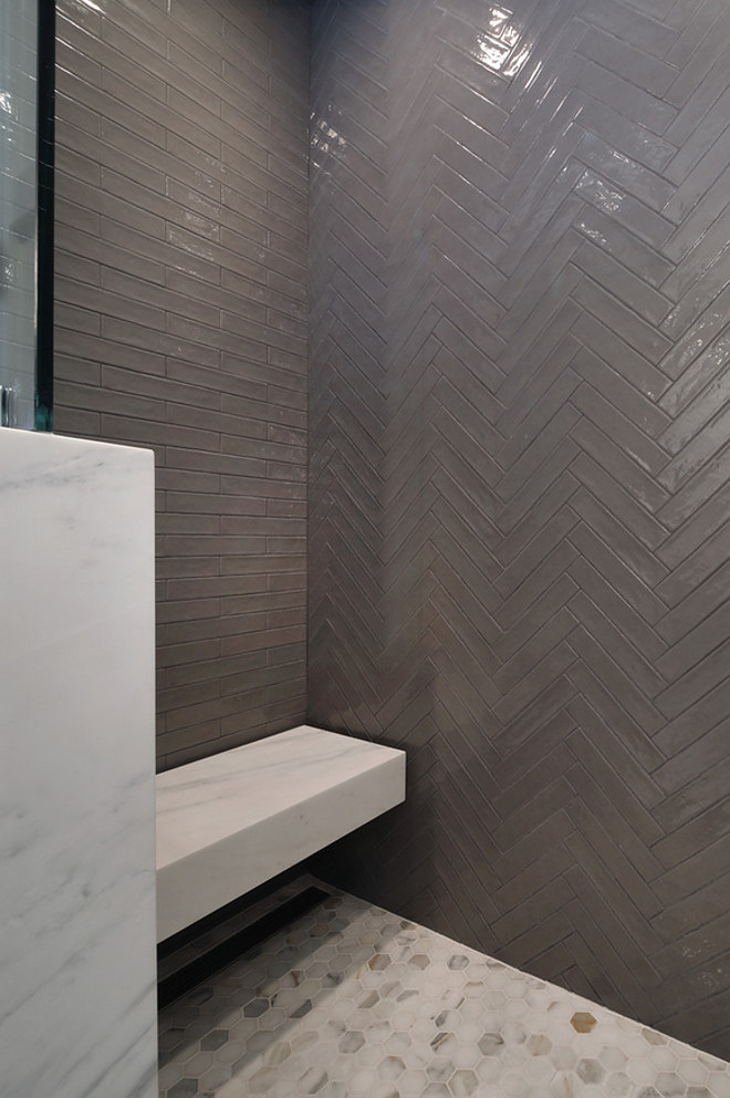 Shower with marble hexagon pieces, and floating shower seat covered in an honed pacific white marble slab. This shower brings quite the design impact with its back wall featuring Italian-made Piastrell Grigio set in a herringbone pattern, floor tiled with 2" marble hexagon pieces, and floating shower seat covered in an honed pacific white marble slab. This shower also features 2" marble hexagon floor tile and a floating shower seat covered in an honed Pacific White Marble slab. Patterson Custom Homes