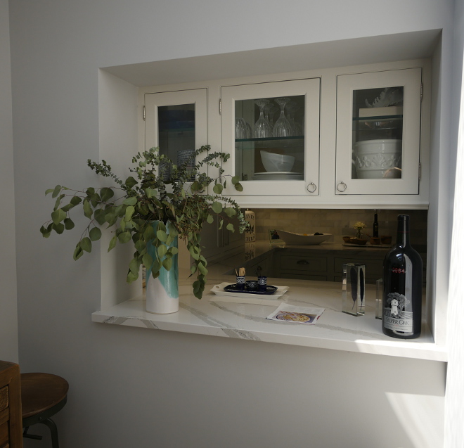 The glass cabinet is glass on both sides. It looks through to a new extension of the dining room. It was once a small interior courtyard the owners enclosed Waterview Kitchens