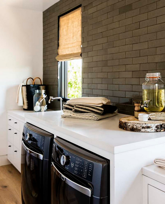 Glazed brick backsplash tile. Laundry room backsplash tile. Farmhouse laundry room with glazed brick backsplash tile. Farmhouse laundry room features glazed brick backsplash tile, crisp white quartz countertop, wide plank hardwood floors and burlap Roman shade #laundryroom #glazedbrickbacksplashtile #glazedbricktile Disc Interiors