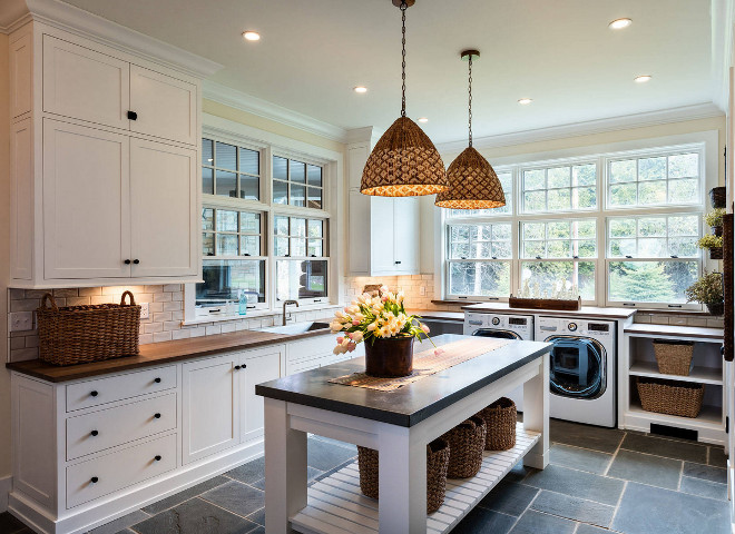 Laundry Room Inspiration Ideas. Laundry room with custom folding island, Blustone floor tile and woven pendants. Pendant lights are from Serena and Lily. #laundryroom #laundryroominspiration #laundryroomisland #foldingisland Mitch Wise Design,Inc.