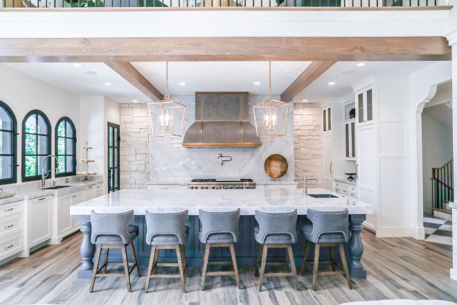 Modern Farmhouse Kitchen. Modern Farmhouse Kitchen with black windows, large island and white marble slab backsplast and countertops. #ModernFarmhouseKitchen #ModernFarmhouse #Kitchen #blackwindows #largeisland #whitemarble #slabbacksplast #countertops Tree Haven Homes. Danielle Loryn Design