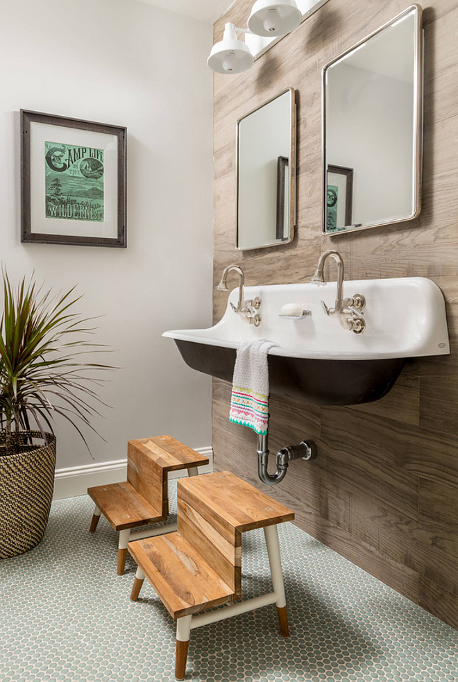 Farmhouse Bathroom with Wood Grain Tile Accent Wall. Kids bathroom with wall-mounted Kohler sink Farmhouse Bathroom with Wood Grain Tile Accent Wall #FarmhouseBathroom #farmhouse #bathroom #wallmountedsink #WoodGrainTile Jamie Keskin Design