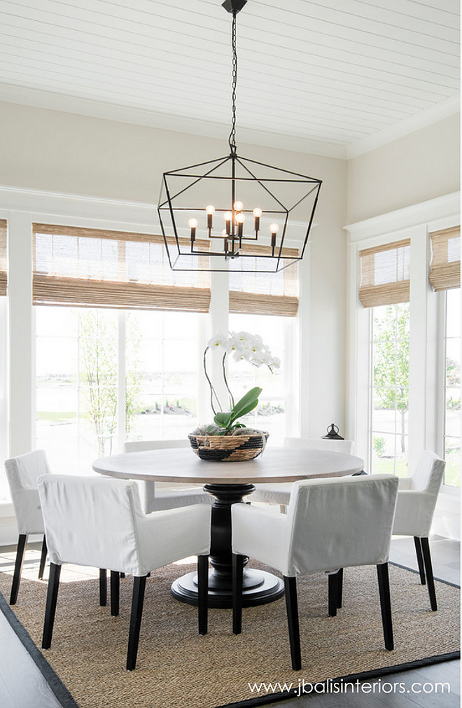 Farmhouse dining room. Farmhouse dining room with a simple design approach and a stricking lighting. Wall paint color is Classic Gray by Benjamin Moore. This #farmhouse dining room features a simple design approach enhanced by a striking lighting. Simply gorgeous! #Lighting is Gabby Decor. #farmhouse #diningroom Judith Balis Interiors 
