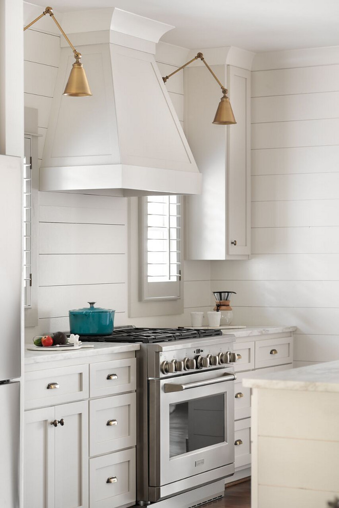 Shiplap kitchen. White kitchen with shiplap backsplash and shiplap walls with shaker style cabinet and brass lighting flanking hood. #kitchen #shiplap #backsplash #kitchenshiplap #shiplapkitchen #hood Willow Homes