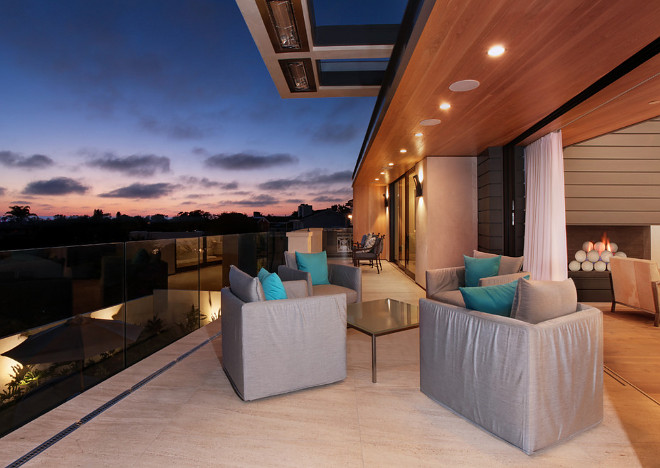 Contemporary home concrete deck with glass railing and folding patio doors. Brandon Architects, Inc.