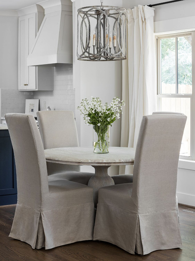 Round white oak dining table with slipcovered chairs and weathered metal lighting. This breakfast room is 100% my style! It features a round white oak dining table, linen slipcovered dining chairs and a weathered metal lighting. Breakfast room with Round white oak dining table with slipcovered chairs and weathered metal lighting. Round white oak dining table with slipcovered dining chairs and weathered metal lighting #Roundwhiteoakdiningtable #Roundwhiteoaktable #slipcovereddiningchairs #weatheredmetallighting Willow Homes