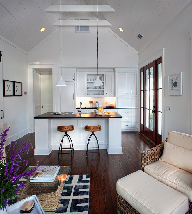 Cottage Open Concept Interiors painted in Benjamin Moore Simply White. The floor is reclaimed engineered pine - stain is 1/2 walnut, 1/2 ebony - finish is matte. Ceiling height is about 15'