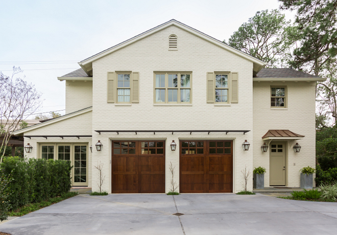 Cottage Style Guest House with painted brick exterior and wood garage doors and window shutters