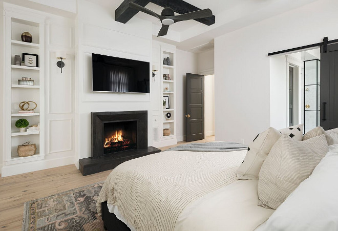 Modern Farmhouse Bedroom Fireplace. One of our favorite features in this master bedroom is the Basalt stone fireplace surround selected by the interior designer. The black wood beams in the ceiling continue our black/white theme throughout this custom home. Another fun feature is the decorative bookcase on either side of the fireplace. Modern Farmhouse Bedroom Fireplace. Modern Farmhouse Bedroom Fireplace. Modern Farmhouse Bedroom Fireplace Modern Farmhouse Bedroom Fireplace Modern Farmhouse Bedroom Fireplace #ModernFarmhouse #Bedroom #Fireplace A Finer Touch Construction