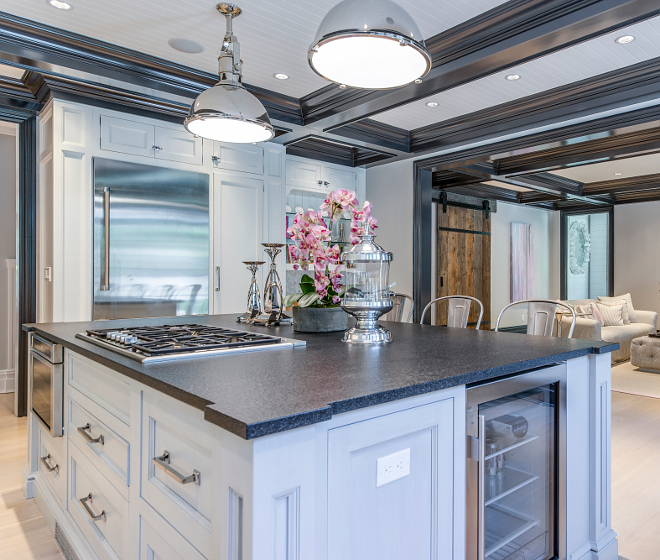 The island countertop is black absolute granite with a leather finish to give it texture and dimensions, the black island top was chosen to compliment the black coffered ceiling