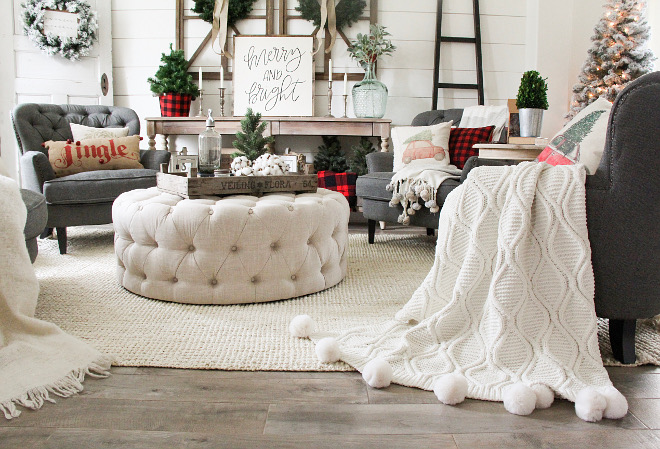Living room Christmas pillows and pompom throws, round ottoman coffee table and braided rug